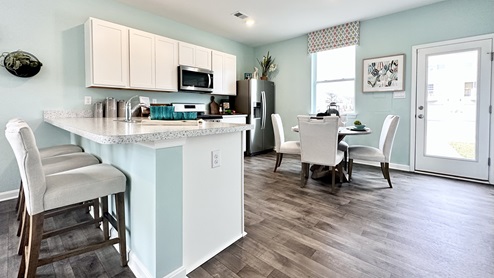 Bright kitchen with peninsula island and white cabinets.