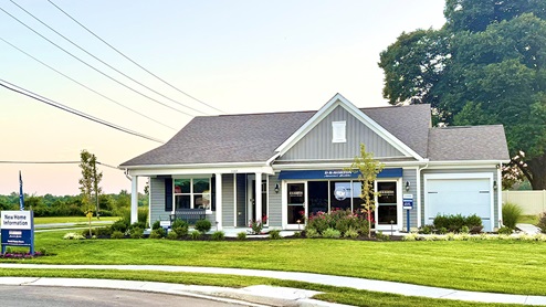 The Birdsong Village model home with blue siding and a three-car garage.