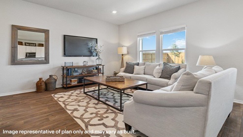 Open-concept living area with hard surface flooring facing spacious kitchen.