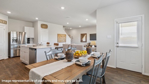 Open-concept dining area overlooking spacious kitchen with hard surface flooring.