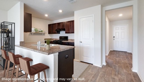 D.R. Horton san antonio solana ridge near lackland air force base the garland 1151 square feet entryway leading to kitchen with island and brown cabinetry