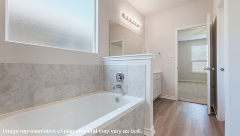 Bulverde Texas DR Horton Homes Copper Canyon The Caspian floor plan 2597 square feet two story New Construction Homes master ensuite bathroom with hard surface flooring separate garden tub with tile surround frosted window white cabinets large vanity mirror with bright overhead lighting