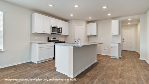 entryway leading to kitchen with spacious kitchen island, stainless steel appliance, abundant cabinets and a corner pantry