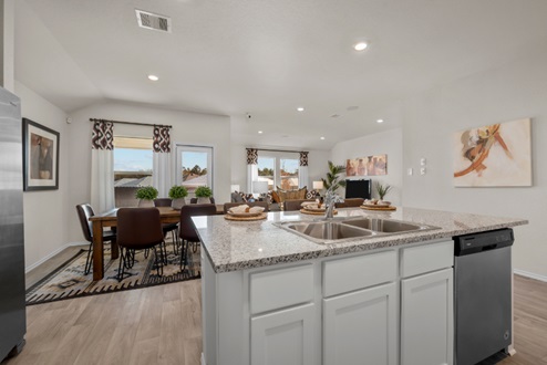 Rockbridge Model Home open-concept kitchen with white cabinetry, granite countertops, and vinyl plank flooring.
