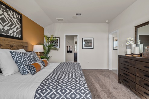 Rockbridge Model Home primary bedroom with carpeted flooring and bathroom entry.