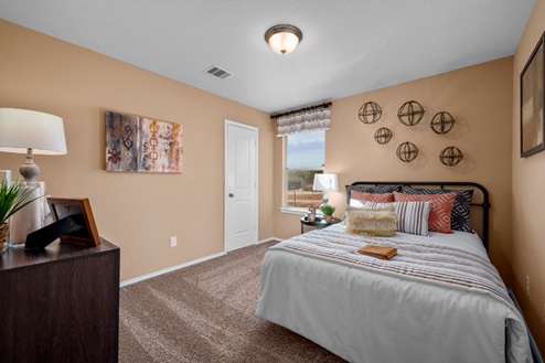 Rockbridge Model Home secondary bedroom with carpeted flooring, closet, and window.