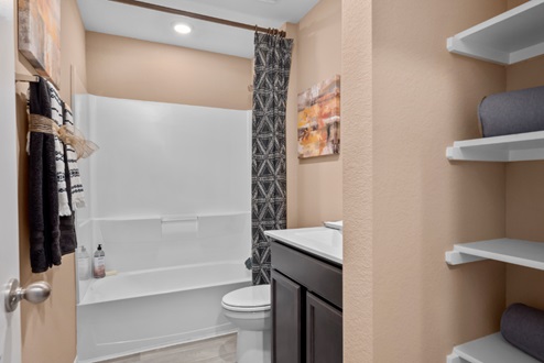 Rockbridge Model Home secondary bathroom with granite vanity and shower tub ceramic tile surround.