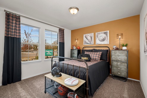Rockbridge Model Home secondary bedroom with accent wall and carpeted flooring.
