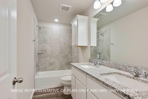 Sonoma secondary bathroom with white cabinets, granite countertops, ceramic tile shower surround and vinyl plank flooring.