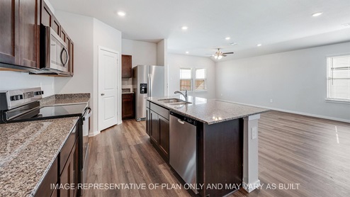 Camden kitchen with granite countertops, island, and vinyl plank flooring,