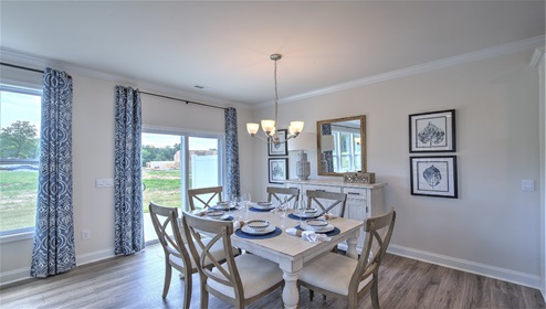 Dining area next to kitchen, large windows