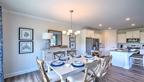 Dining area next to kitchen, large windows