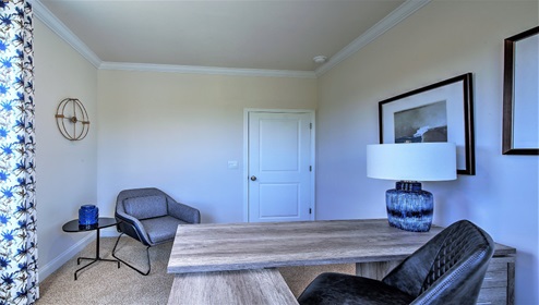 Carpeted flex space being used as an office, large window
