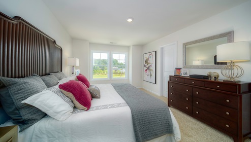 Carpeted primary suite with two large windows