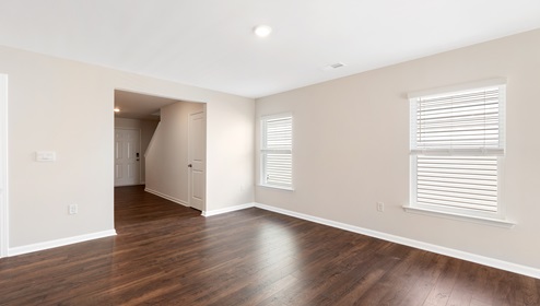 Open living room beside kitchen with windows and sliding glass back door. New home in Asheville, North Carolina