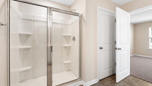Primary bathroom with glass door shower. New home in Asheville, North Carolina