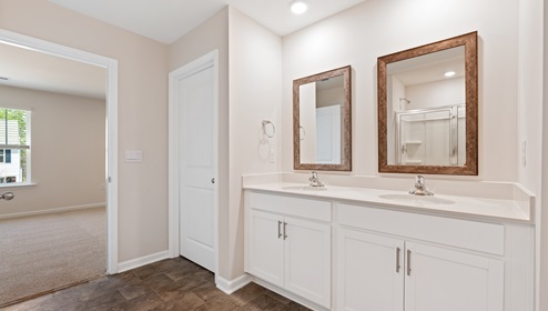 Primary bathroom with double sink vanity and white cabinets. New home in Asheville, North Carolina