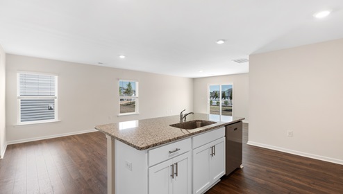 Kitchen and island with white cabinets, and stainless steel appliances. New home in Asheville, North Carolina