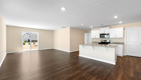 Kitchen and island with white cabinets, and stainless steel appliances. New home in Asheville, North Carolina