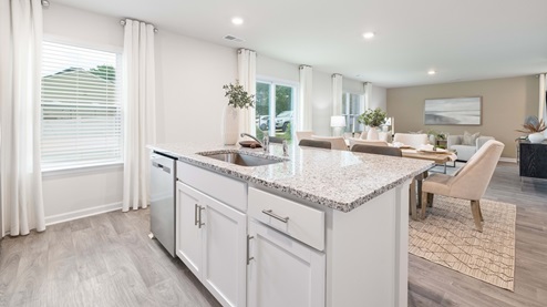 Kitchen and island with white cabinets, granite countertops and stainless steel appliances