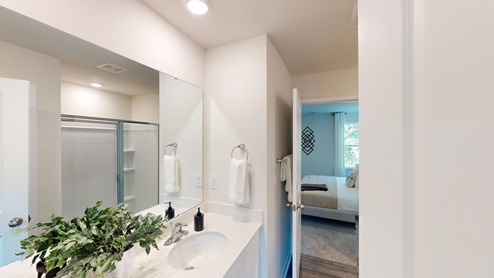 Primary bathroom with double sink vanity, and large standing glass door shower