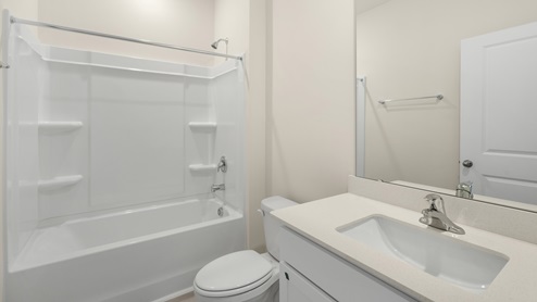 Bathroom with quartz counters and a bathtub
