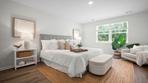 Primary bedroom with a bed and side table
