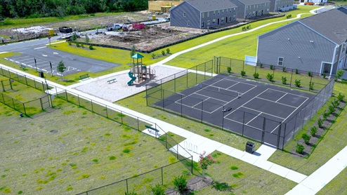 Residents have access to a range of amenities such as a well-equipped clubhouse, a fitness room, a spacious competition swimming pool, a kiddie pool, a hot tub, a sports court, a playground, and picturesque nature trails for walking.