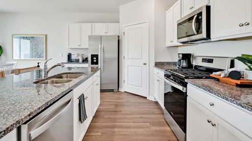 The kitchen features beautiful cabinets, granite countertops, and stainless steel appliances, which are sure to both turn heads and make meal prep easy. You’ll never be too far from the action with the living and dining area right there.