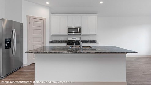 Spacious kitchen with island and stainless-steel appliances.