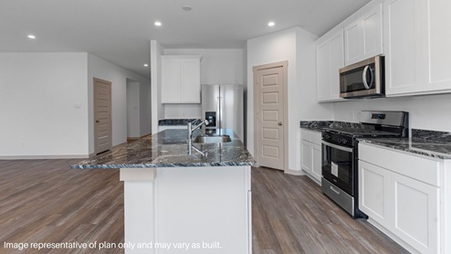 Spacious kitchen with island and stainless-steel appliances.
