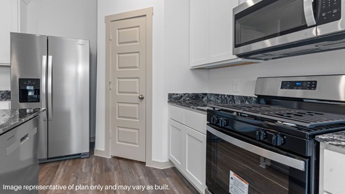 Spacious kitchen with island and stainless-steel appliances.