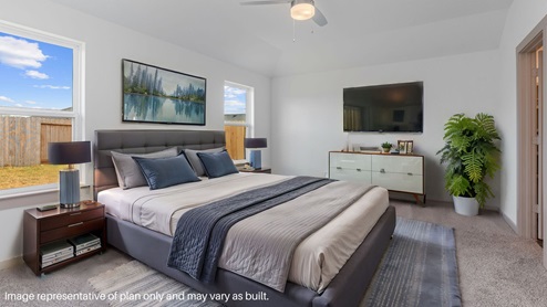 Spacious primary bedroom with carpet flooring and two bright windows.
