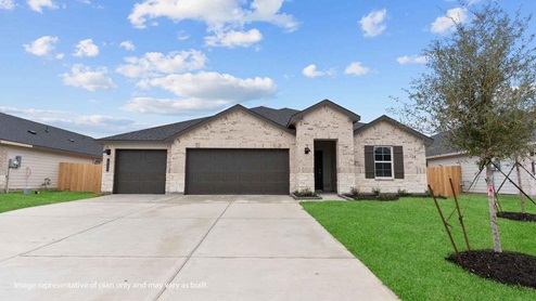 Single story brick home with a three car garage