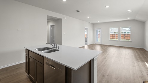 Kitchen area with hardwood floors dark cabinets and white countertops