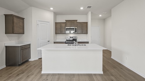 Kitchen area with hardwood floors dark cabinets and white countertops