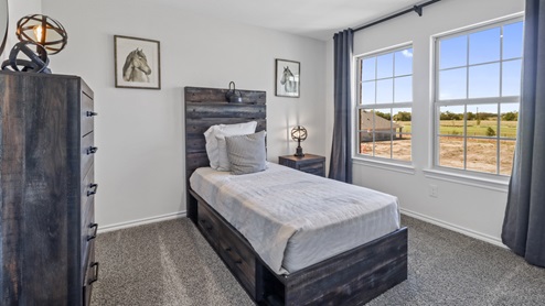 Secondary bedroom with carpet white walls and large windows providing natural light