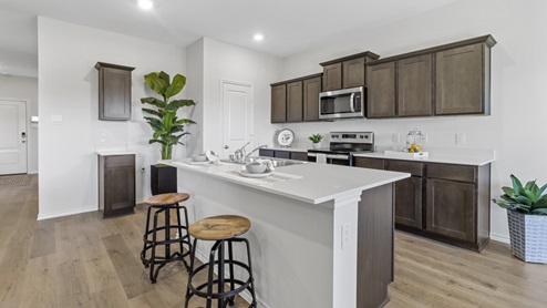 Kitchen area with hardwood floors dark cabinets and white counters