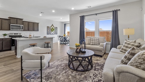 Open concept living area with hardwood floors with large windows providing natural light