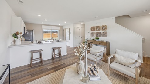 modern kitchen with white cabinetry, stainless steel appliances, 2 counter stools, and a large sliding door to the backyard