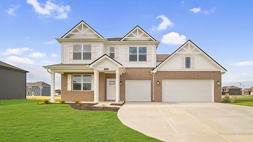 two story home with 3 car garage and white siding and brown brick