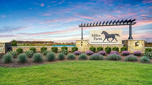 welcome to Miles Farm, monument at sunset