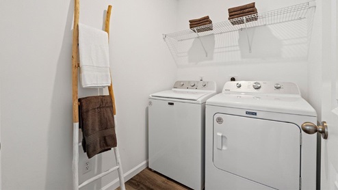 Colonial Heights Bellamy model home laundry room with LVP flooring and wire shelving for storage
