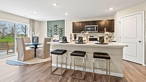 Parlor Bluffs Henley Model Kitchen, kitchen island, and dining table space with LVP flooring throughout.