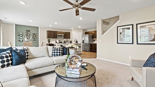 Parlor Bluffs Henley Model Home Living room with carpet flooring and large 52" ceiling fan