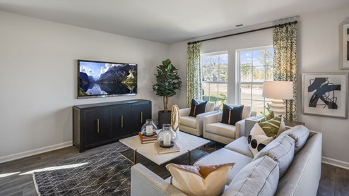 Open Concept living room with a sofa and 2 recliners and a tv.