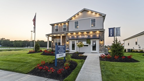Front exterior side view of model home at Grandstone Trace community at dusk