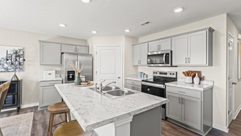 Kitchen with large island with marble countertops.