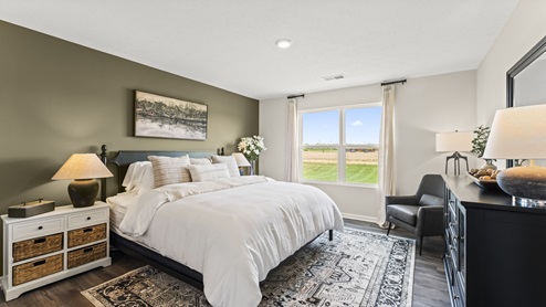 Bedroom with a large window for natural lighting.