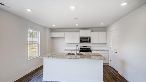 kitchen with single window, white cabinets, stainless appliances, walk in pantry, built in island